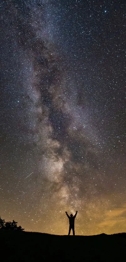 Silhouette under a starry Milky Way galaxy night sky.