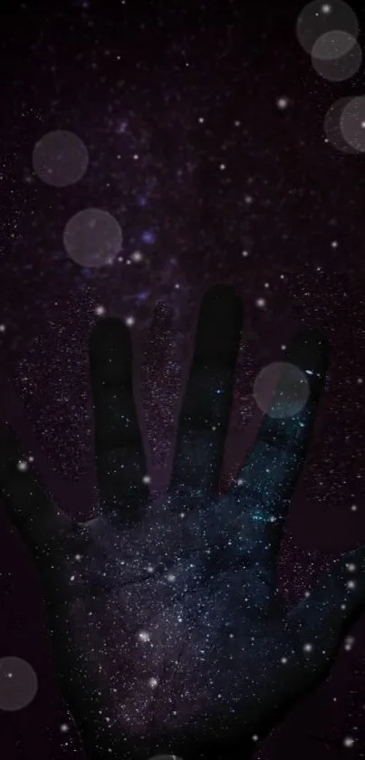 A silhouette of a hand with a starry galaxy background in dark purple hues.