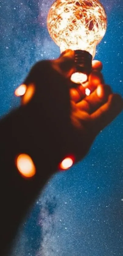 Hand holding glowing lamp against starry night sky.