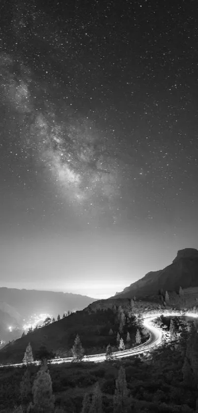 Starry sky over a winding mountain road at night.