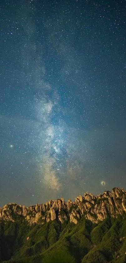 Starry night sky over rugged mountain landscape.