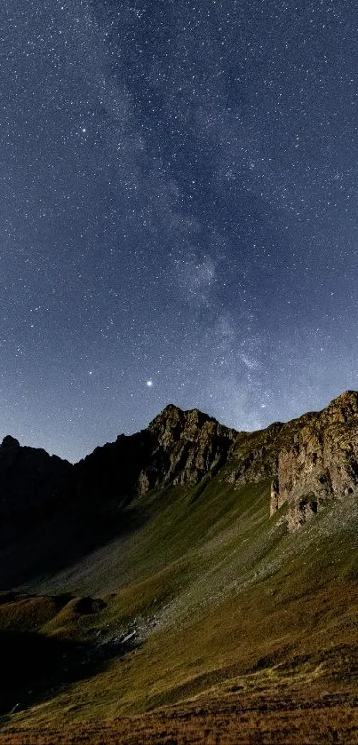 Starry night sky over a rugged mountain landscape.