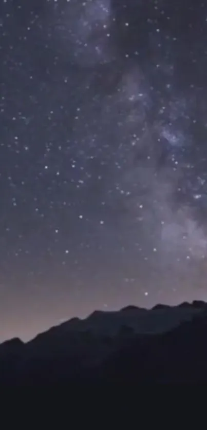 Starry night sky over mountains, featuring the Milky Way.