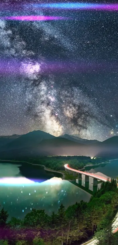 Milky Way over mountains with illuminated winding road and lake.