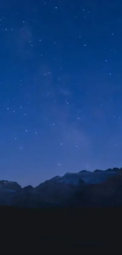 Starry night sky above mountain silhouette in tranquil scene.