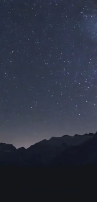 Stunning starry night sky with silhouetted mountain peaks in deep blue hues.