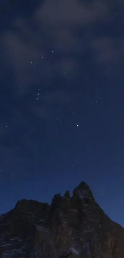 A star-filled night sky above a mountain peak.