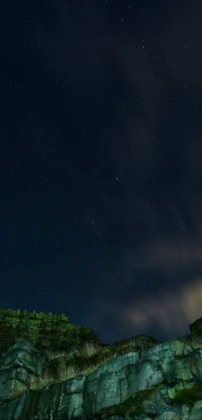 Starry sky over rocky cliffs with clouds.