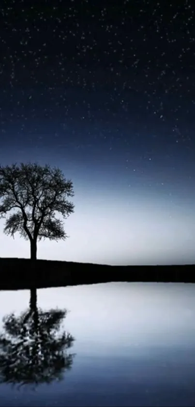 A lone tree reflecting in a lake under a starry night sky.