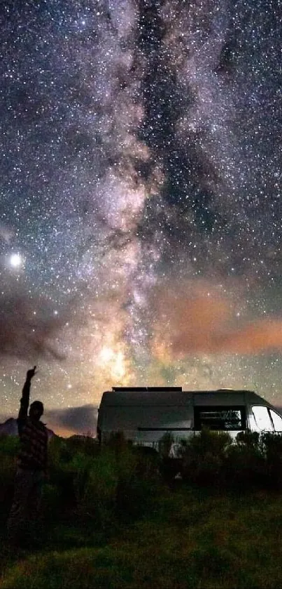 Night sky with milky way above camper van in serene landscape.