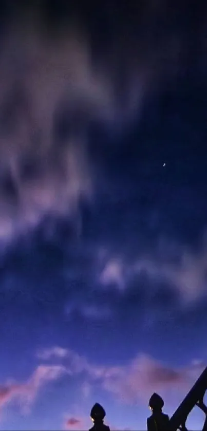 Starry night sky with wispy clouds and a hint of railing silhouette.