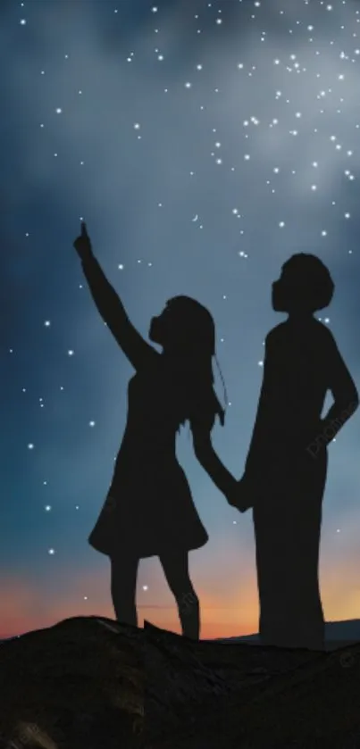 Silhouette of couple under a starry night sky.