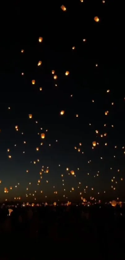 Floating lanterns illuminate a dark sky with a mesmerizing glow.