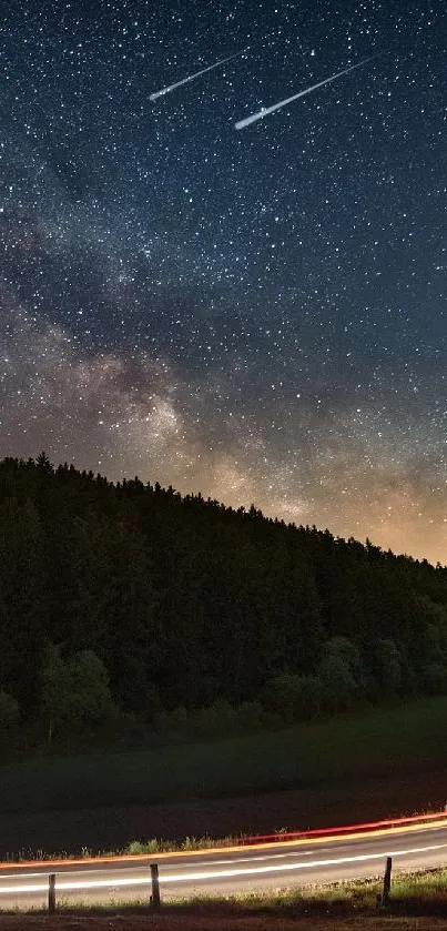 A starry night sky over a winding road surrounded by a dark forest.