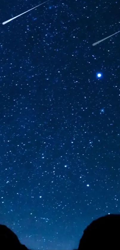 Starry night sky with shooting stars and dark mountains.