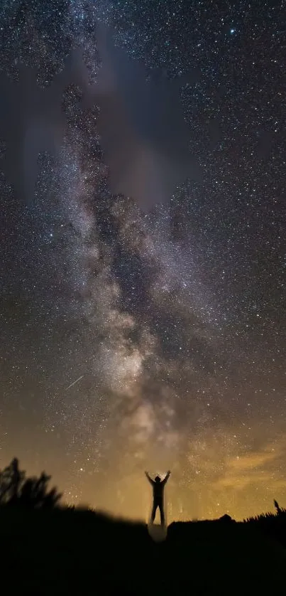 Silhouette under starry night sky with Milky Way in view.