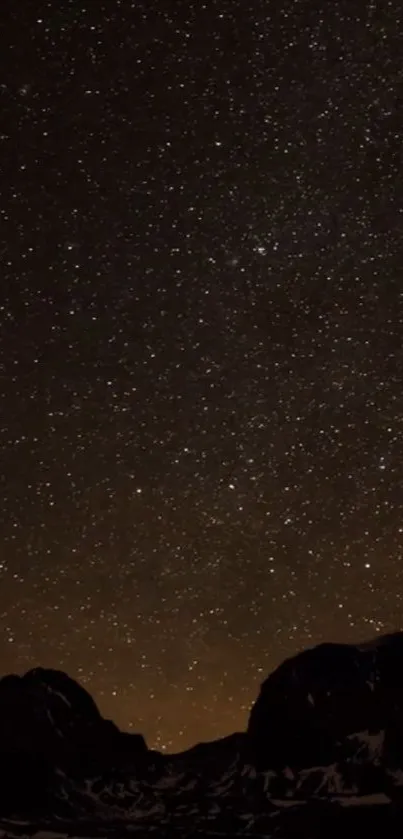 Starry night sky with mountains silhouetted in the foreground.