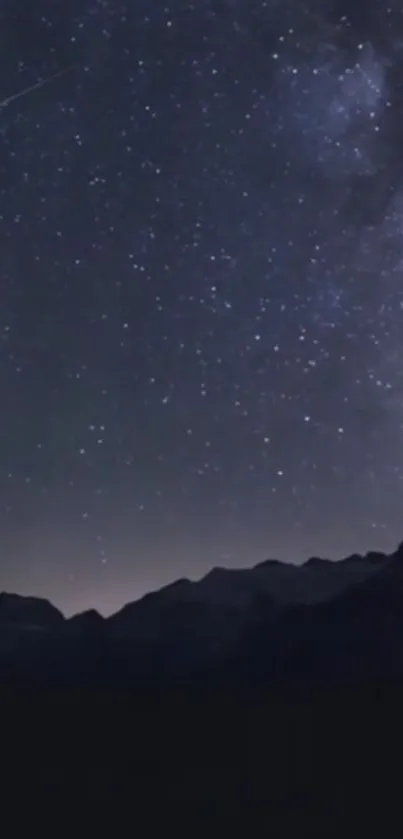 Starry night sky over dark mountains with a galaxy view.