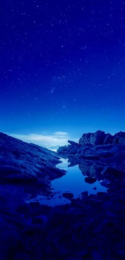 Mobile wallpaper of a starry night sky over rocky terrain in deep blue hues.