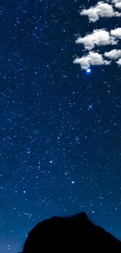 Starry night sky with silhouette and clouds.