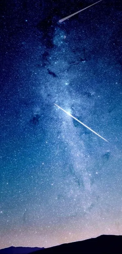 Starry night sky with shooting stars over a dark horizon.