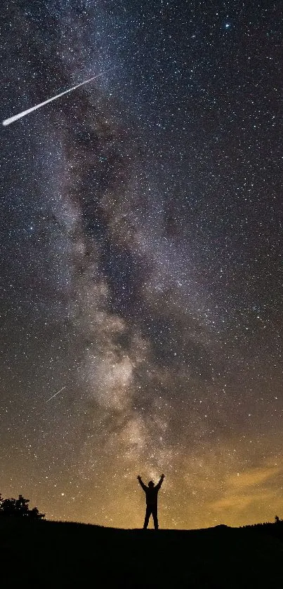 Silhouette under starry night sky and Milky Way.