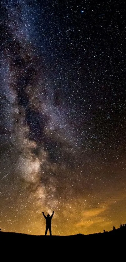 Silhouette under a starry night sky with the Milky Way galaxy above.