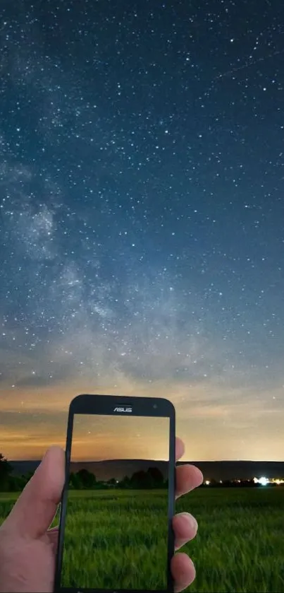 A smartphone capturing a starry night sky with a vibrant horizon.