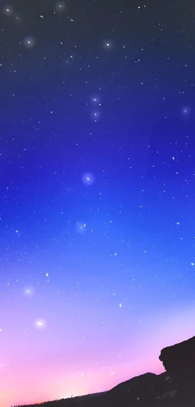 Starry sky during twilight with blue and pink gradient and silhouette.