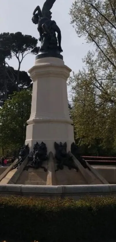 Statue in a lush, green urban park with trees.