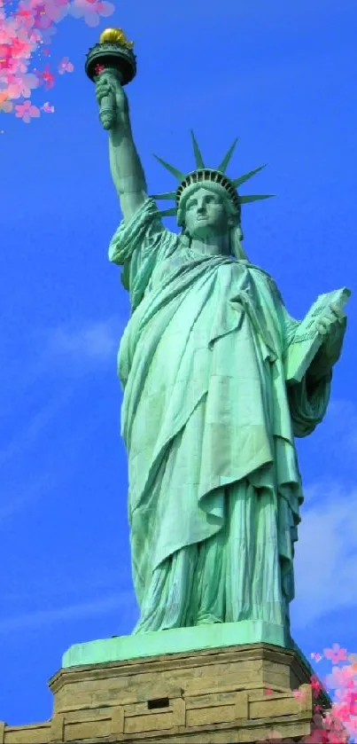 Statue of Liberty with cherry blossoms under a blue sky wallpaper.