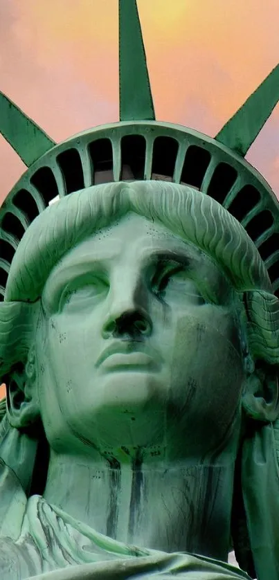 Statue of Liberty at dusk with orange and pink sunset sky.