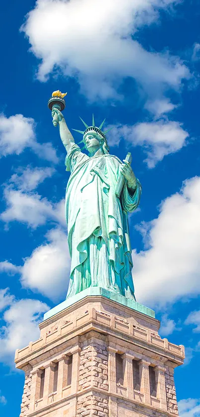 Statue of Liberty with blue sky background, viewed from a low angle.