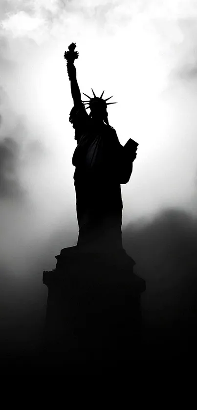 Silhouette of the Statue of Liberty against a cloudy sky.