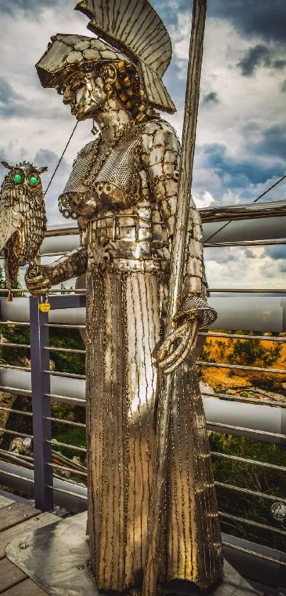 Metal statue with owl on bridge under cloudy sky.