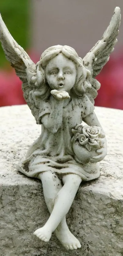 Stone angel figurine with wings and rosette on textured surface.