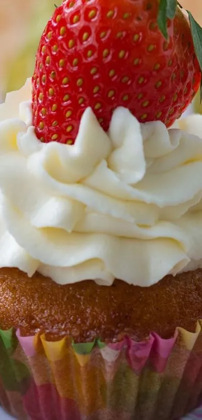 A close-up of a cupcake topped with frosting and a strawberry.