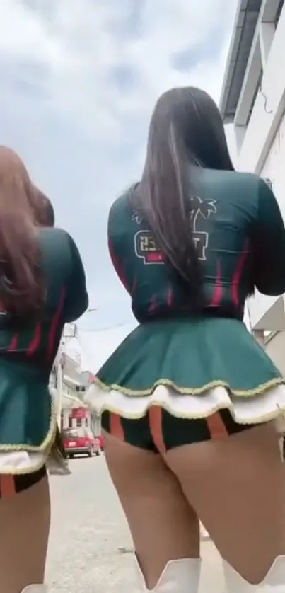 Two women in green outfits walking on a street, showcasing urban fashion.