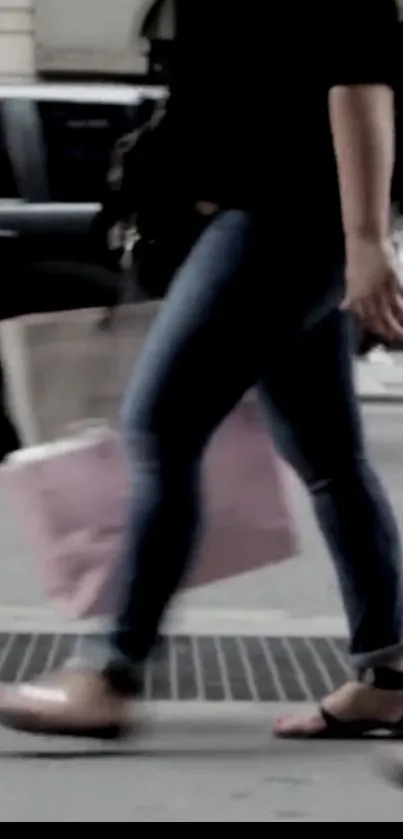 Pedestrian walking on city street with pink shopping bag.