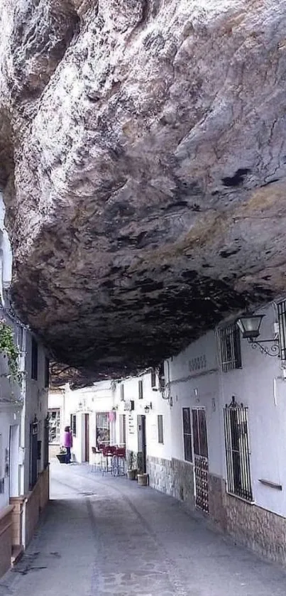 Street under rock archway in Spanish village.