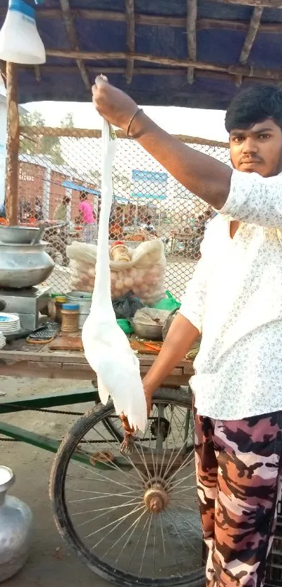 Street vendor holding a bird in a vibrant market scene.