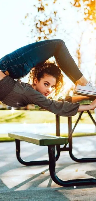 Person doing yoga on park bench in golden sunlight.