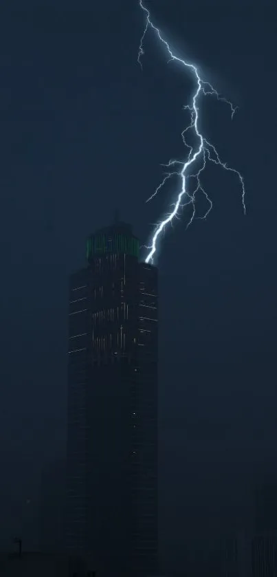 Striking lightning bolt over dark skyscraper at night.