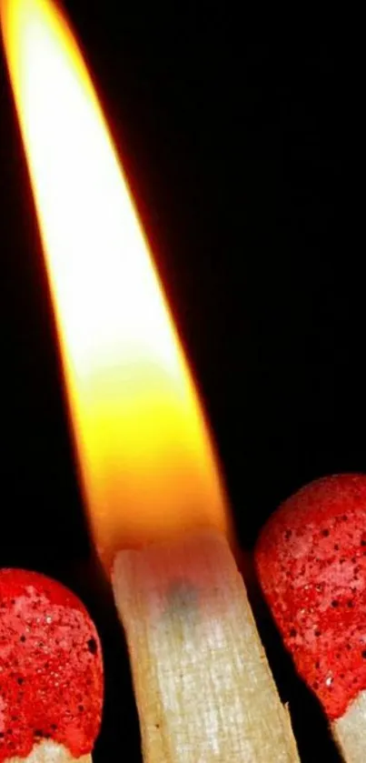 A close-up of a lit matchstick with a bright flame against a dark background.