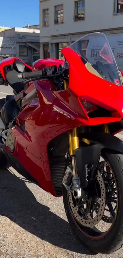 Vibrant red motorcycle parked on a city street under the sun.