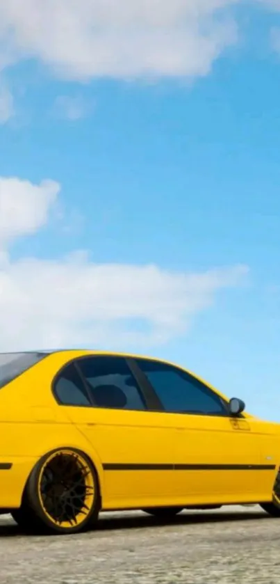 Vibrant yellow car under a clear blue sky with scattered clouds.