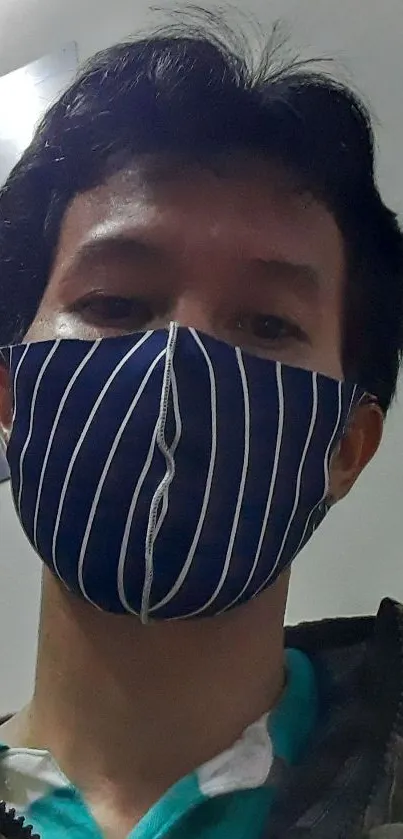 Person wearing a blue striped face mask indoors.