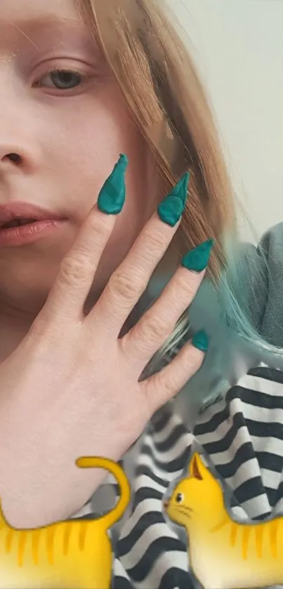 Young person with teal nails and cat emojis on striped shirt background.