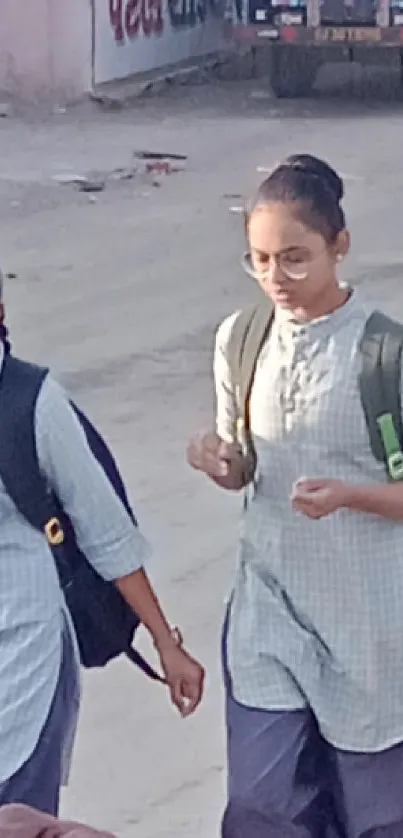 Students walking in school uniforms with backpacks on a city street.