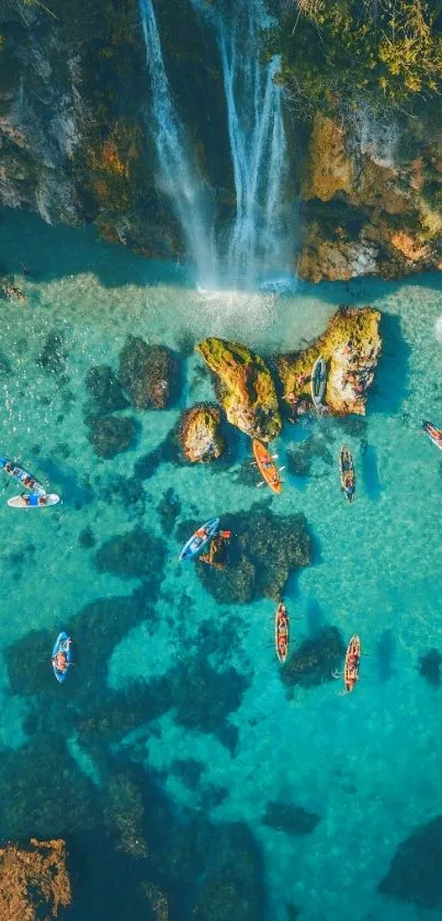 Aerial view of kayakers by turquoise beach waterfall.